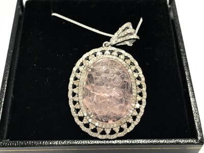 A silver pendant set with a large oval morganite surrounded by diamond a silver chain. Morganite 14ct and 1.16 diamonds approximately.