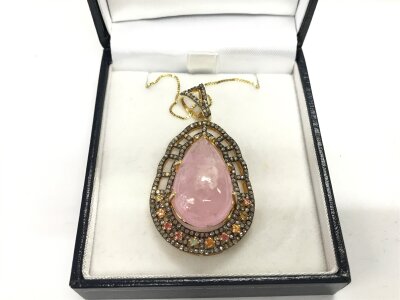 A large silver gilt pendant set with a pear shaped polished cabochon morganite multi coloured sapphires and diamonds on gold plated silver chain. Morganite 15ct approx sapphires 0.60ct approx and 1ct diamonds approx.