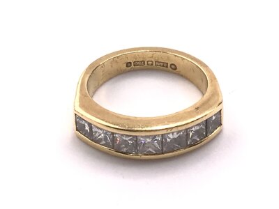 An 18ct gold ring set with seven princess cut diamonds, total 1.75ct, colour G/H, VS/SI
7.37g and size N