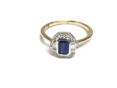 9ct yellow and white gold art deco style ring set with a step cut sapphire and round and baguette cut diamonds. Approx 0.58ct sapphire and 0.20ct diamonds. Size P