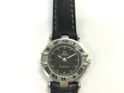 A ladies Omega constellation. 25mm steel case with black leather strap. Quartz movement seen running.