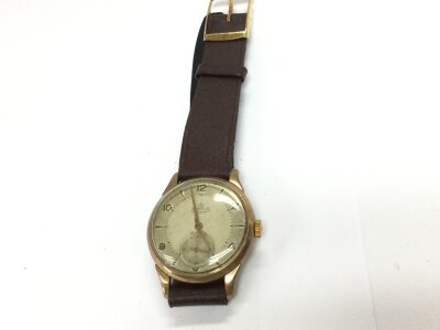 A 9ct gold cased vintage smiths wristwatch with brown leather strap. 30.92g