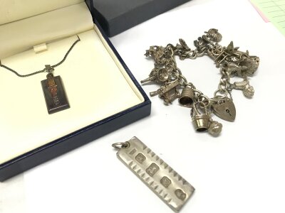 Two silver hallmarked ingots pendants and charm bracelets. Charm bracelet and ingot total weight 86g
