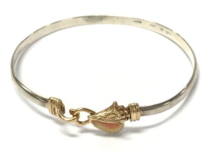 A 14k and silver conch shell design bangle. 9.4g total weight