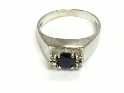 An 18ct white gold ring set with diamonds and a central sapphire. Size M and 4.31g