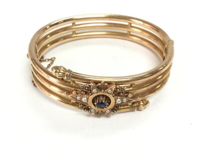 A 14ct gold (possibly gold core) bangle set with seed pearls and a blue stone. Approx 6.5cm and 22.97g