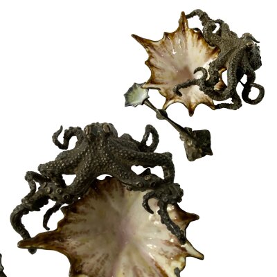 A small extremely well modelled silver plated table salt with spoon, modelled as an octopus holding an enamelled shell bowl engraved crest Senator G. F. H. A. Holthusen" 1902.
