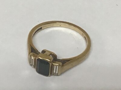 A 9carat gold ring set with a blue stone flanked by baguette stones weight 2g