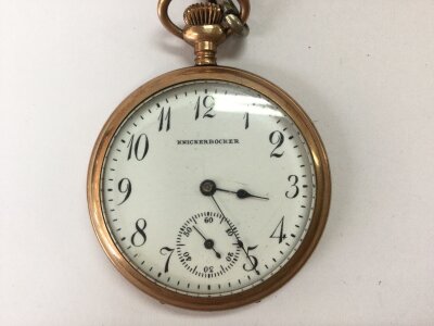 A vintage gold tone button wind pocket watch by Knickerbockers. Winds and seen running. Approximately 50mm case.