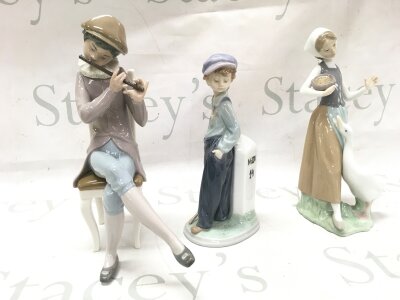 Three Lladro figures including Boy playing flute, The wanderer , girl with goose. 22 and 25cm tall
