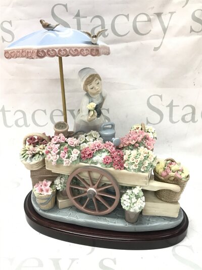 A Lladro figure, Flowers of the Season.  30cm tall, 25cm wide approximately
