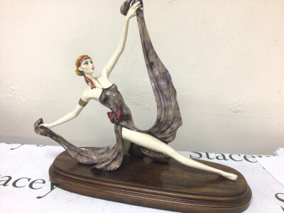 A Retrospective Art Deco figure of a female dancer signed and in a polished beechwood base.