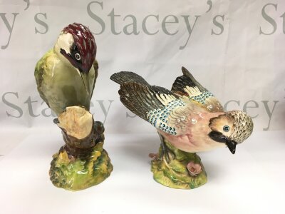 Two Beswick figures of birds comprising a jay and a woodpecker, both a/f. Tallest approx 22cm.