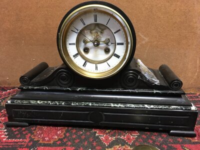 A black slate and marble mantle clock with key and pendulum. 38cm wide 25cm tall