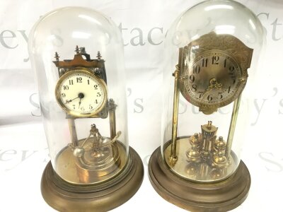 Two antique anniversary style pendulums brass clocks under domes neither seen working.