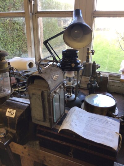 A collection of lamps and other items a Champman Bro 1938 lamp Vapalux lantern as new with instructions a brass pressure gauge a vintage tin money box a Record bench vice heavy duty a British made Vintage anglepose lamp number 3 and other items. 
( Buyer to arrange collection from CM12 0RB. Viewing by appointment. No reasonable bid refused)