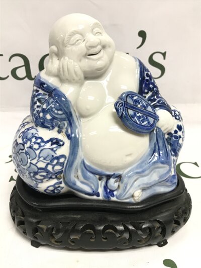 Porcelain Chinese blue and white Buddha figure (16cm tall, 16cm wide) on a wooden stand