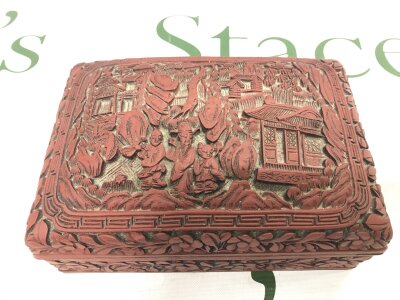 A Chinese cinnabar box with floral and temple scene decorations .  7cm tall 14cm wide.