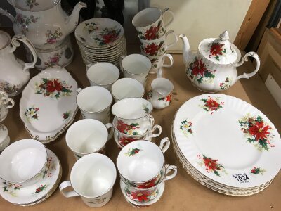 A Royal Doulton part dinner and tea service in the Poinsettia pattern- including tea pot, dinner plates, mugs, cups, saucers etc