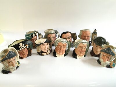 A large collection of Royal Doulton character jugs in a box, small and large mugs