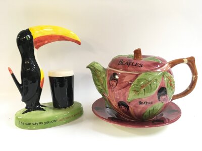 A Carltonware Guinness toucan figure and The Beatles Washington pottery Hanley England apple teapot and plate