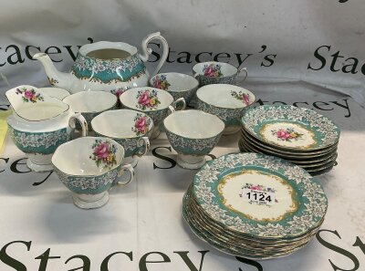 A vintage tea set. This set strongly resembles classic fine china from manufacturers like Royal Albert. The pieces feature a vibrant turquoise ground colour, heavily accented with a crisp white and opulent gold detailing.