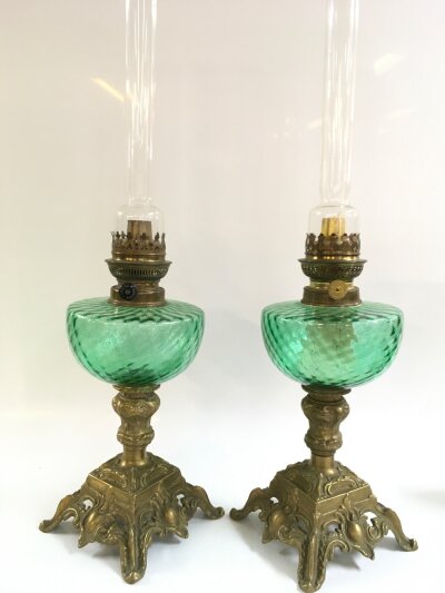 Two early 20th century oil lamps with green glass fonts and ornate brass bases, with Kosmos Brenner style burners. 56cm tall