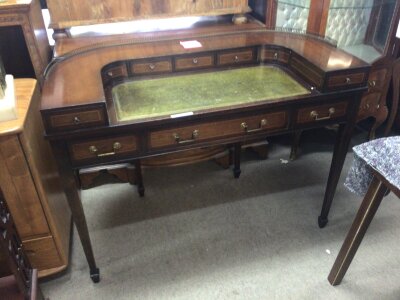 A Mahogany Carlton House type desk the raised back with a brass gallery above small drawers a green leather surface above further drawers on  square tapering legs.85cm high width115cm