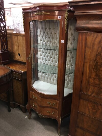 A French style display cabinet with single drawer and two drawers under, having cabriolet legs and gilt metal mounts
