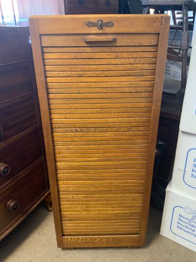 An oak tambour fronted file cabinet. 45.5” x 18.5” x 15”