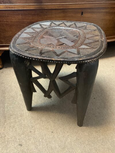 A vintage hand carved Nupe stool from Nigeria with intricate geometric patterns 15” High, together with a hand carved paddle.