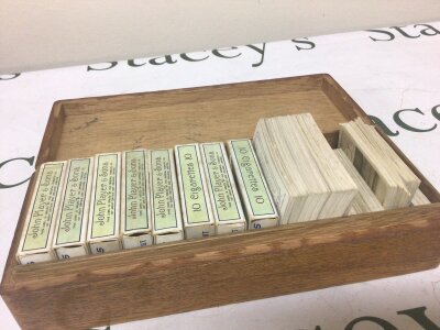 A box containing a collection of sets of John Players Cigarette cards.