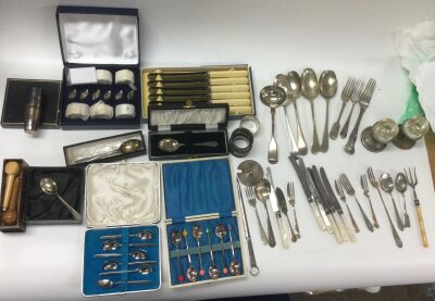 Mixed lot of cutlery including two silver pieces (spoon and napkin ring). William Mitchell lion cutters no.467 original wooden-handled set, boxed, made in Birmingham, England. Cased spoon sets: Viners of Sheffield 6-piece tea/coffee spoon set; Art Deco harlequin bean spoons. Silver-plated cutlery, assorted fiddle/old English pattern spoons,forks,mother-of-pearl handled knives, bone effect cutlery. Tablewear, swam-shaped menu holders, napkin rings,small condiment bases,silver-plated letter opener. All a must have in the collectors industry.