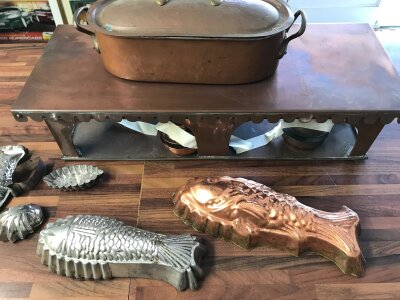 A mixed lot including copper warming base complete with lamps, a fish kettle and various moulds etc.