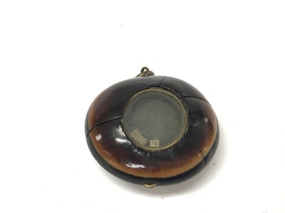 A rare bore war prisoner of war carved coffee bean with small dice inset in the top. 
Approximately 35mm wide by 30mm high.