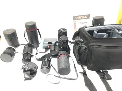 A Pentax SLR camera with additional lenses.