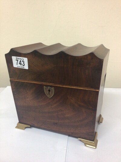 An unusual late George III mahogany tea caddy with a shaped hinged top and brass fittings.