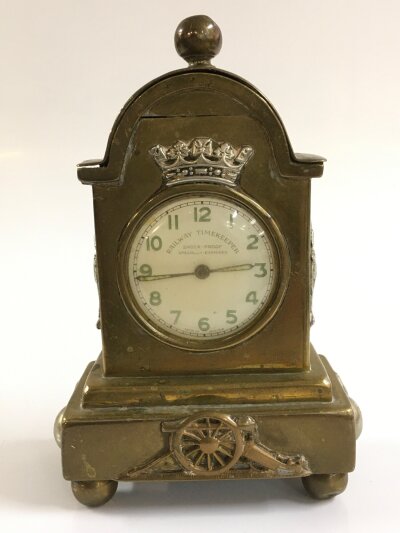 A Railway Timekeeper pocket watch housed in a brass enclosure with interesting British military cap badges implanted in design