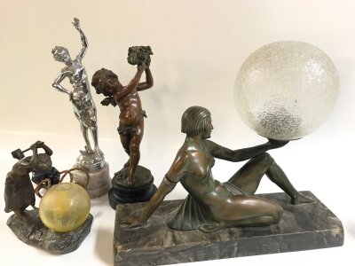 Four figures including a sculpture lamp of a blacksmith worker signed Mednat Paris , art deco lady lamp with damaged arm, French spring love cherub, chrome art deco figure