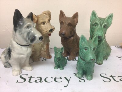 A collection of four  large Vintage Sylvac dogs including an unusual 1209 glazed dog a brown coloured dog with Sylvac ware label all with impressed marks to the base. With two small dogs no obvious damage maximum height 28cm