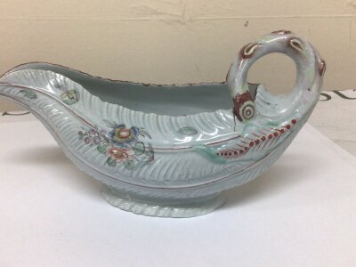 A Worcester mid 18th Porcelain Century sauce boats of naturalistic form decorated with sprays of flowers and impressed moulded pattern has firing cracks. length 22cm.