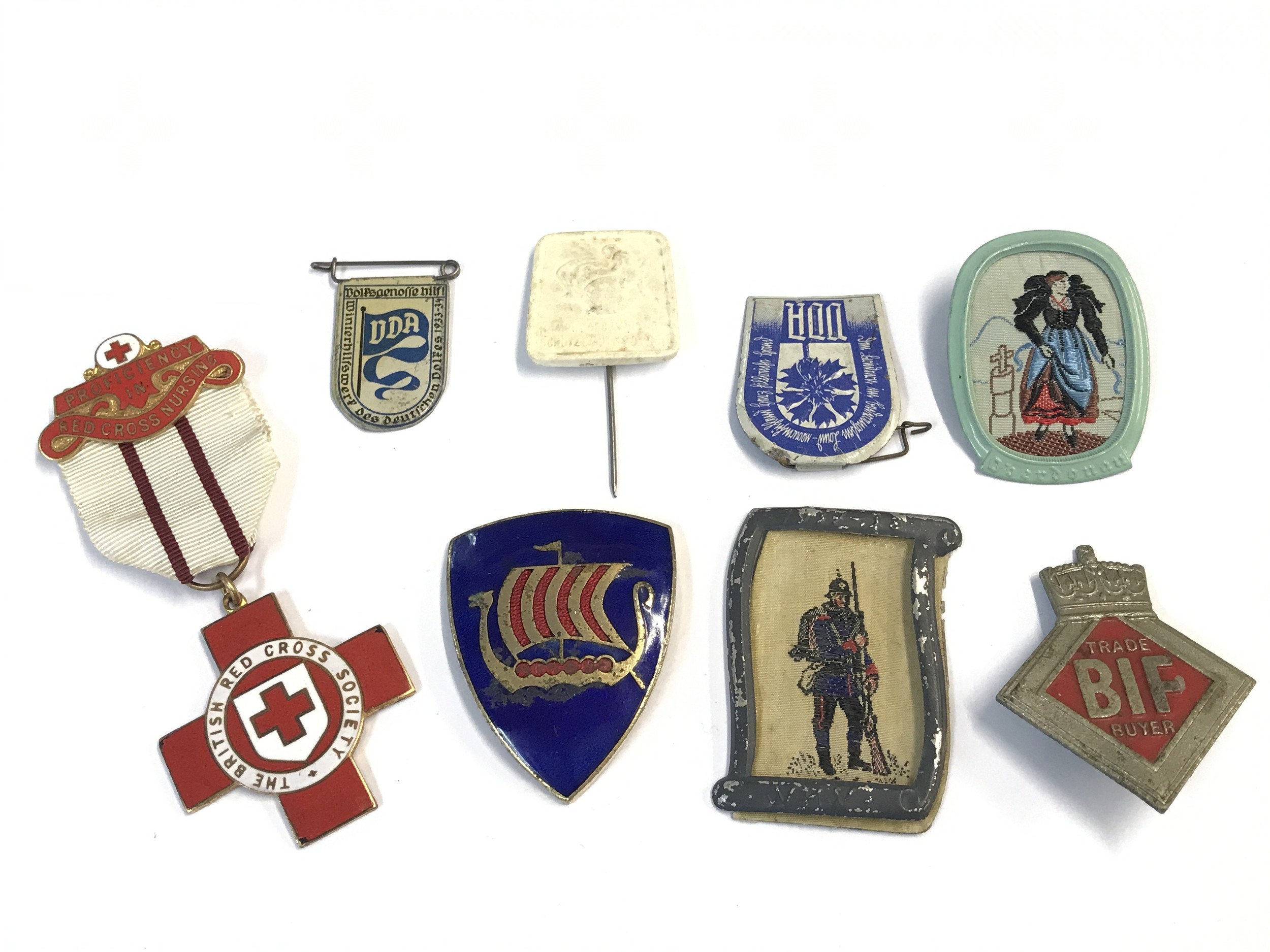 A collection of Badges including a British BIF trade buyers badge numbered back A32276 rare badge, a British Red Cross medal awrded to 39390 NH Rouse and other mid 20th century badges.