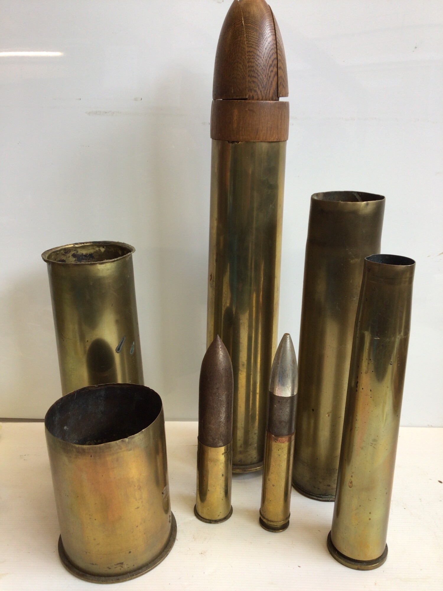 A collection of mixed size brass shell cases two with inert tops. (7)