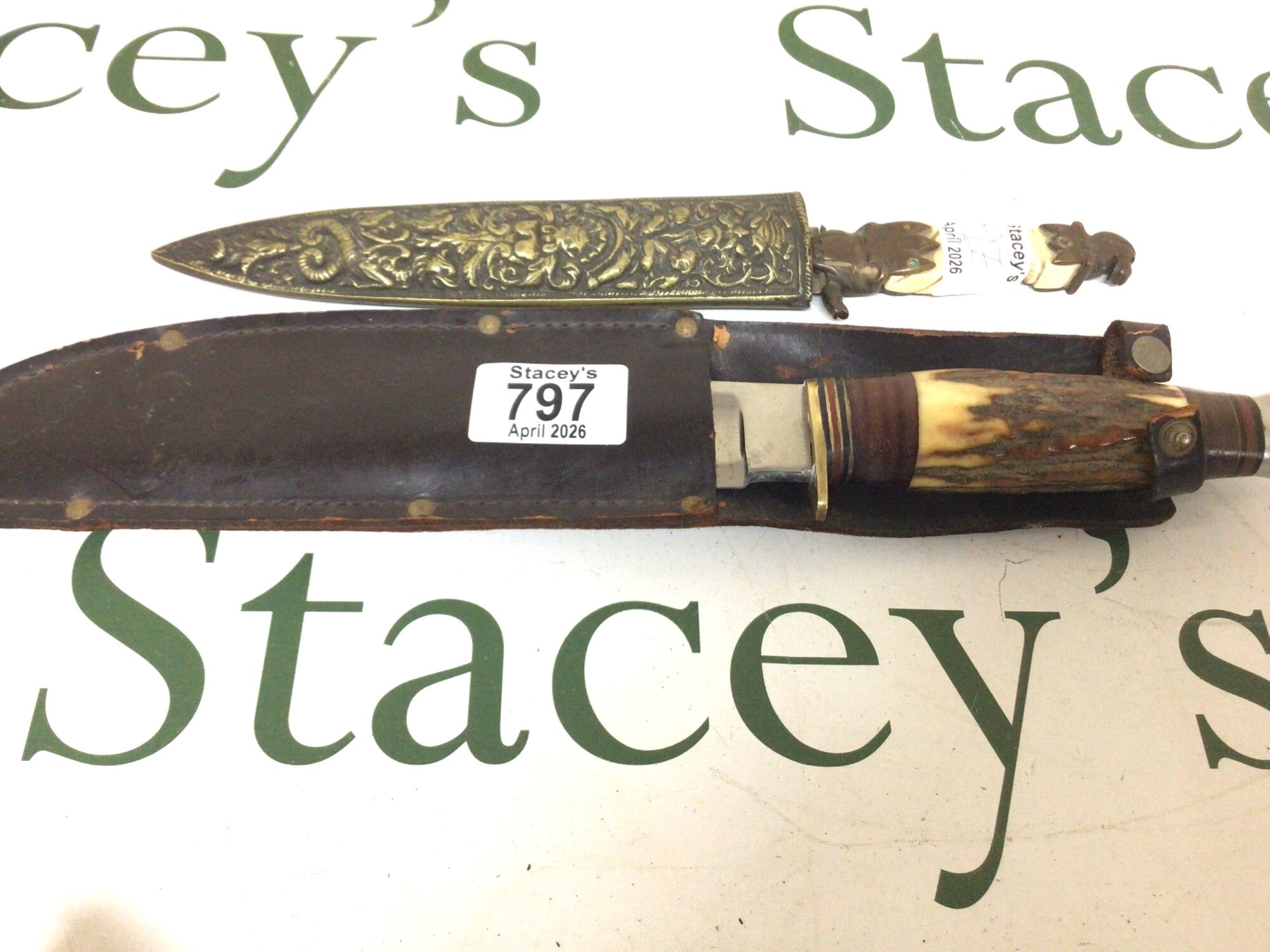 A small antique dagger with bronze mounts and and elaborate brass scabbard and a Vintage Sheffield made hunting knife with a horn handle Bowie Knife maker J Rowhill & Son. (2)