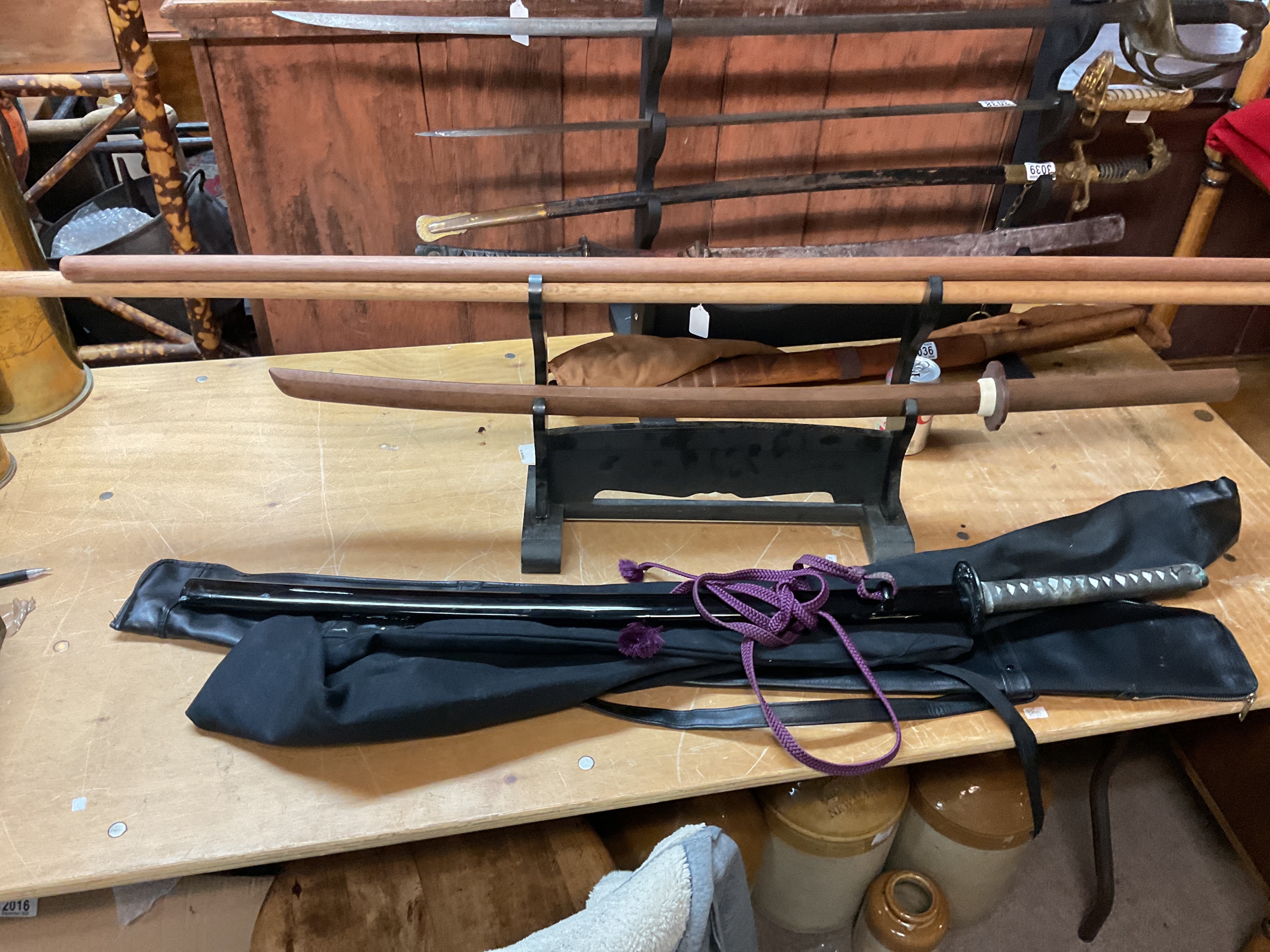 Kendo club members training swords and Bo Staffs.on display stand , wooden sword with Mokko tsuba.