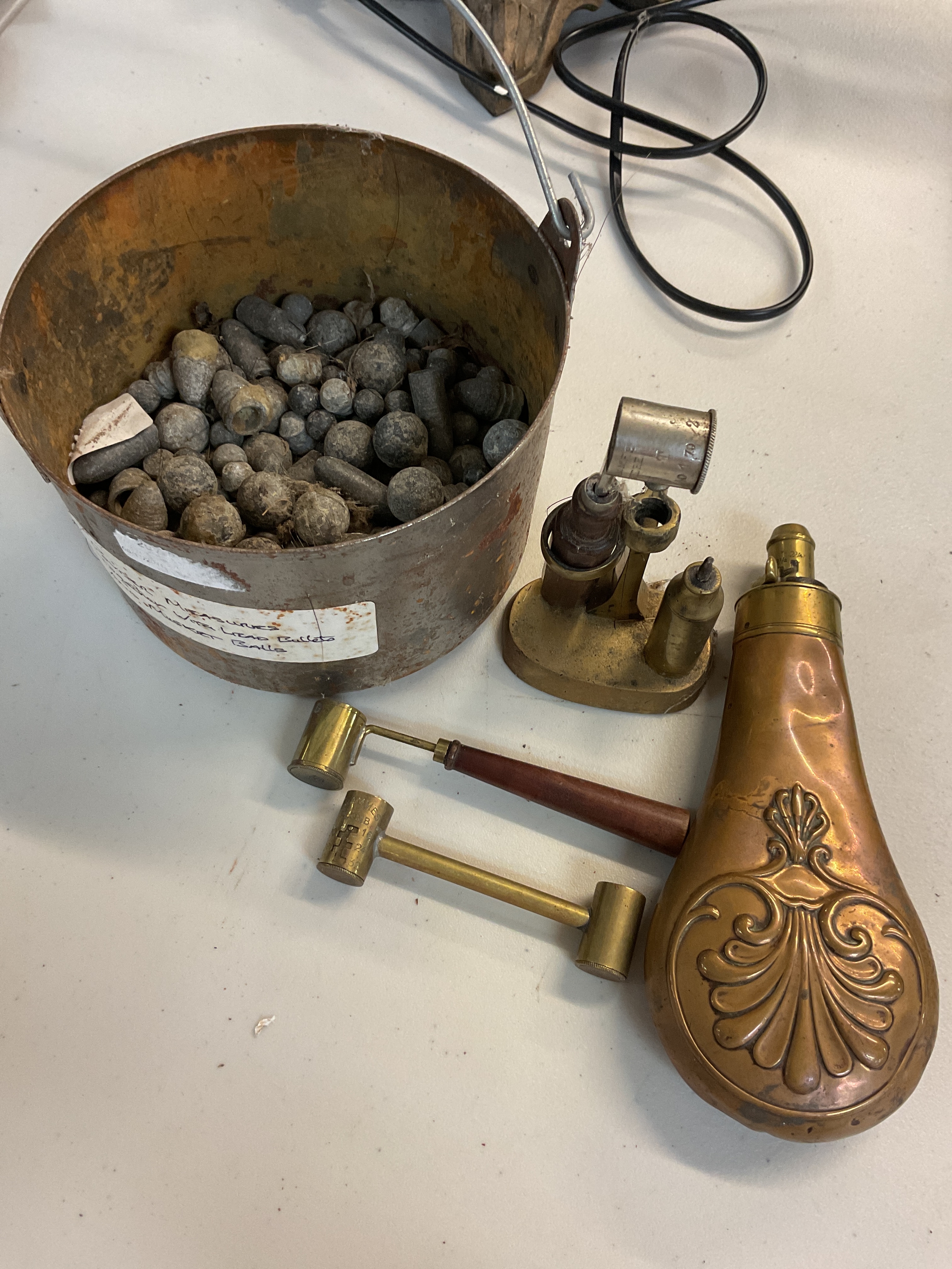 A collection of two powder measures together with lead bullets and musket balls and powder flask 