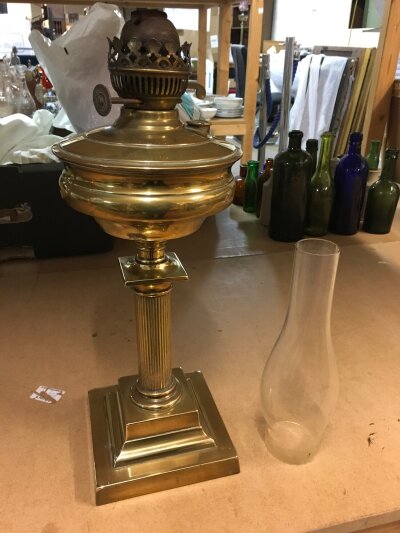 A brass oil lamp with classical column and glass chimney
