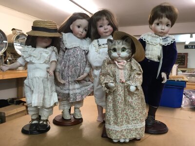 Four China dolls in Victorian style costume, together with a China Cat doll in Victorian dress and bonnet