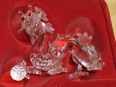 A Boxed Swarovski Chinese dragon chasing a pearl, having red eyes