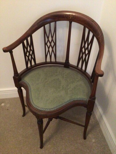 An Edwardian inlaid mahogany occasional chair with a shaped top rail and shaped seat thecinlaid legs  with stretchers.